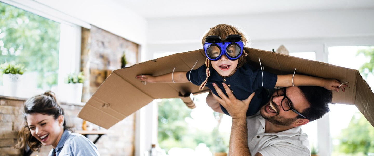 Junge mit Flugzeug aus Pappe