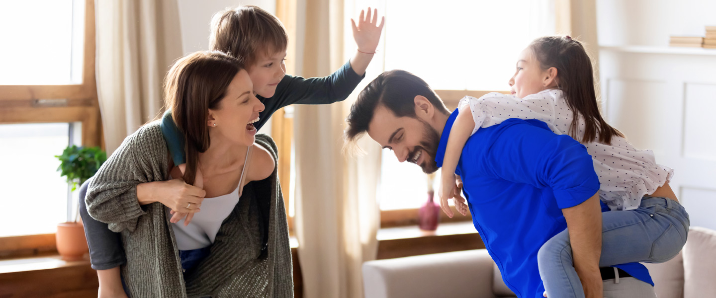 Eine Familie tobt zusammen im Wohnzimmer