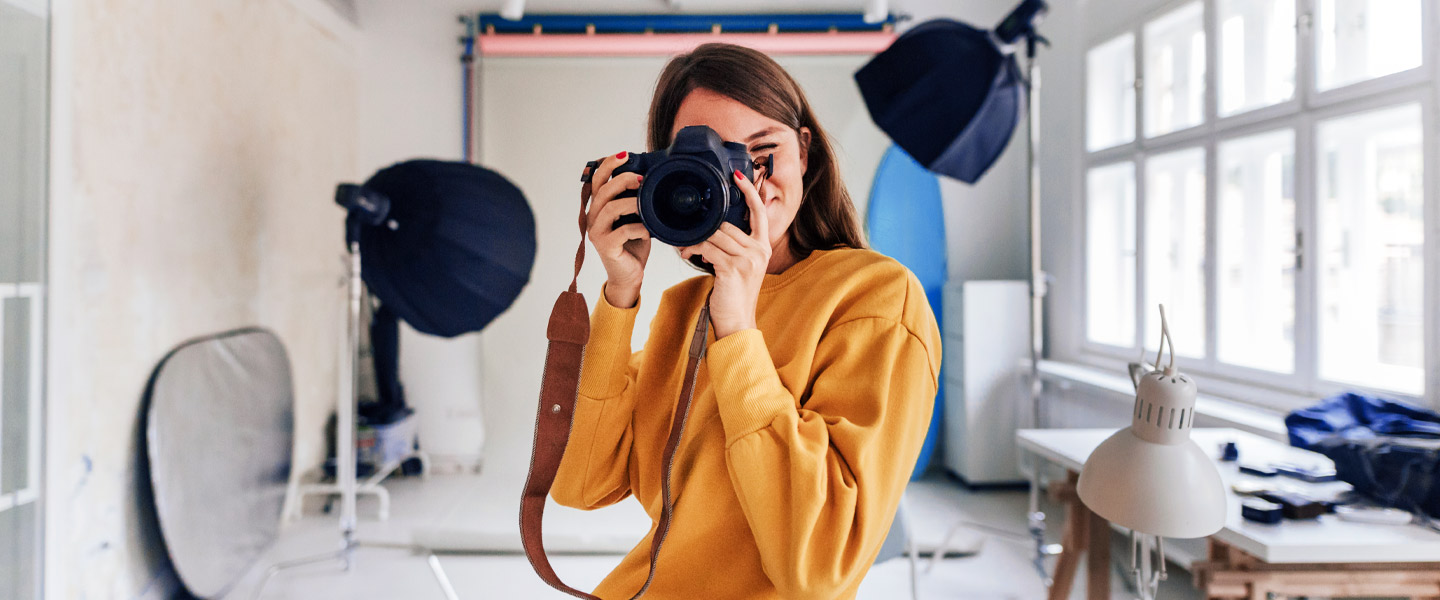 Frau in ihrem Fotoatelier mit Kamera.