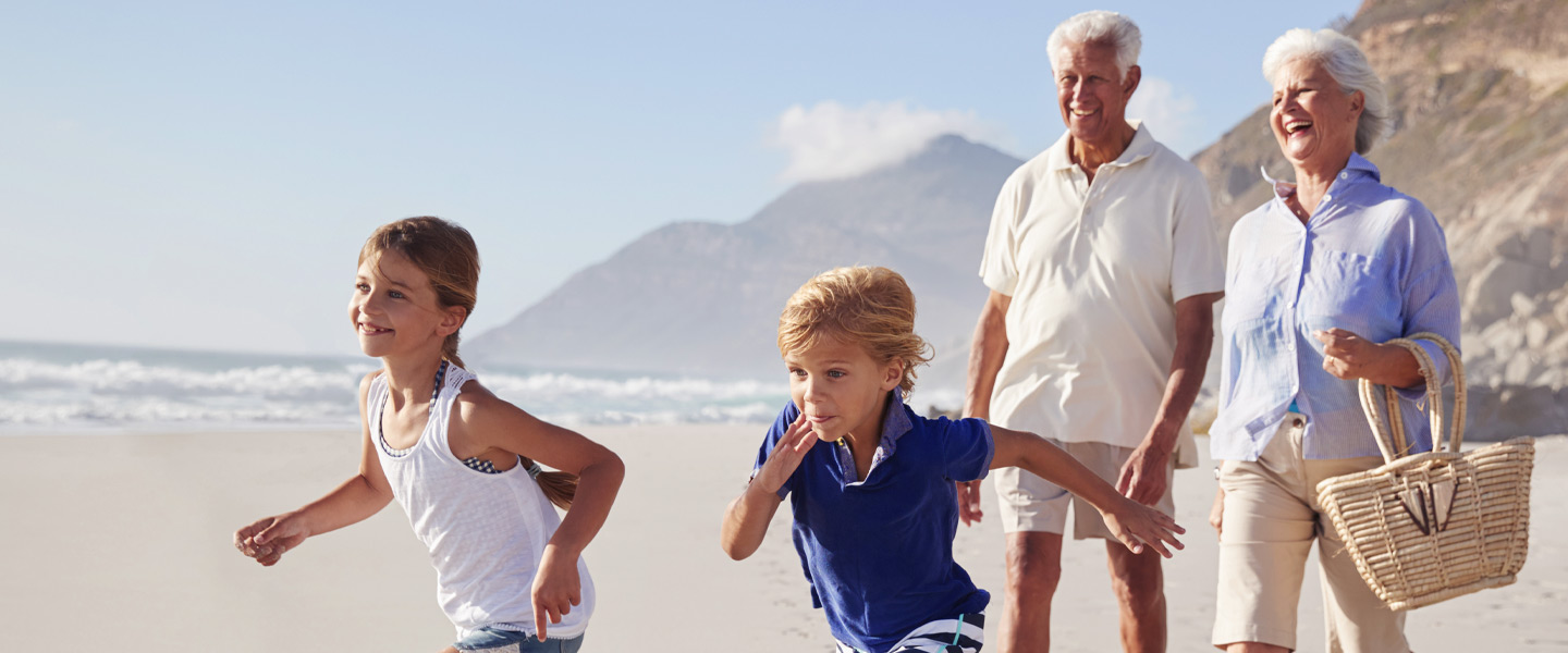 Großeltern mit Enkelkindern am Strand